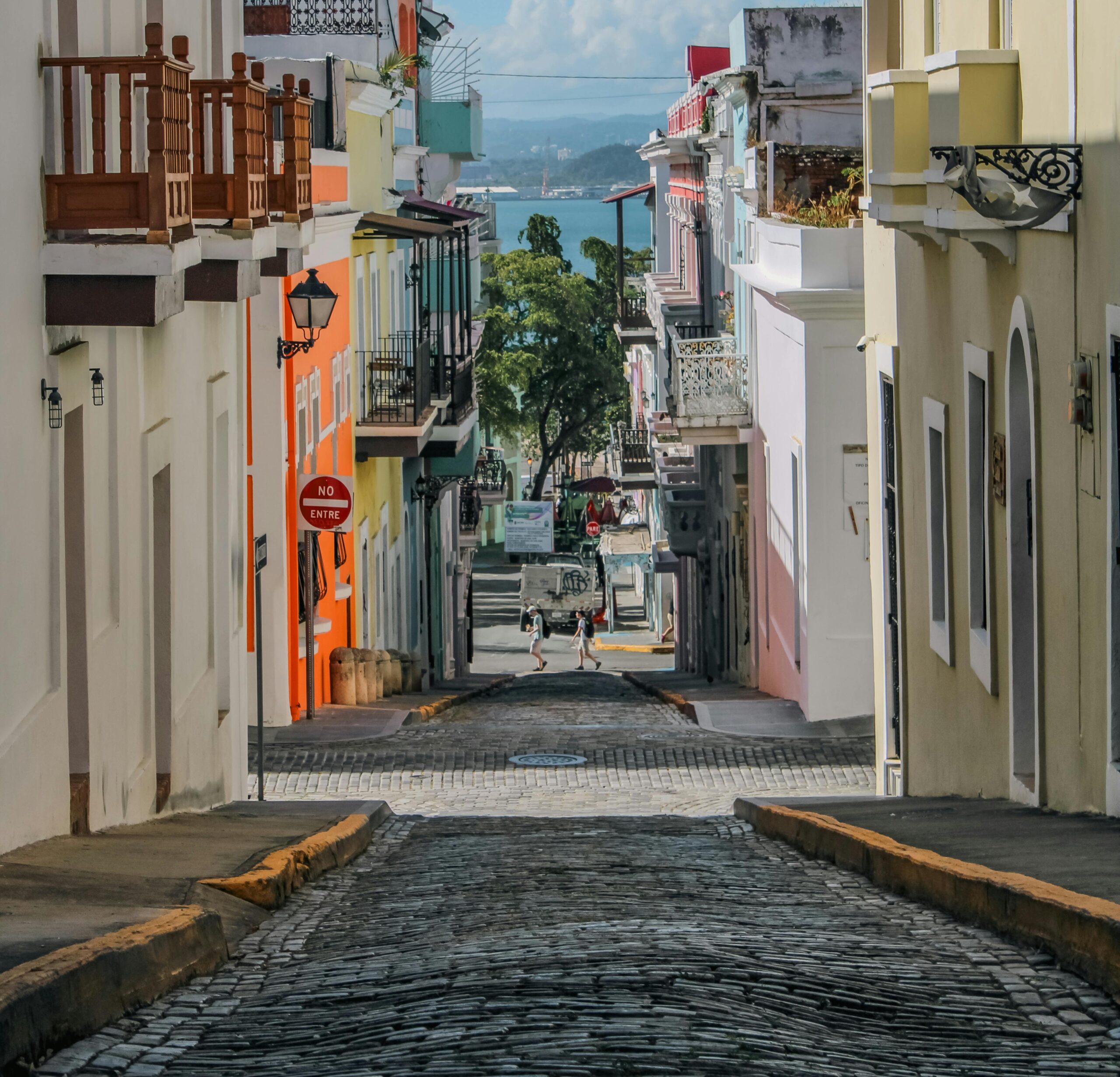 Cobblestone street in Old San Juan, Puerto Rico, lined with colorful historic buildings and balconies.