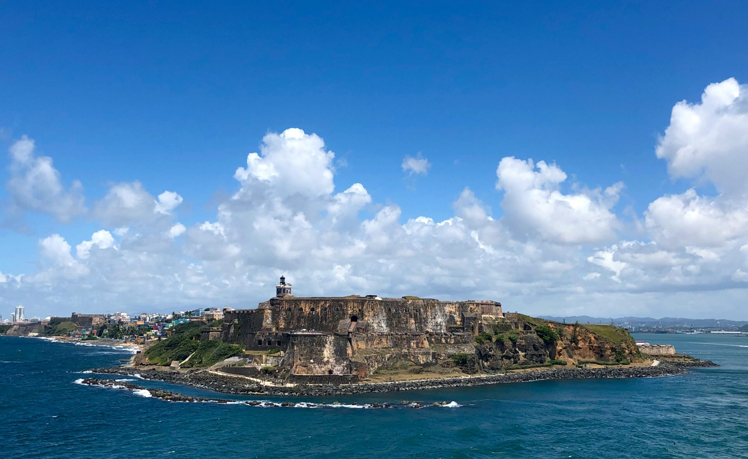 Castillo San Felipe del Morro fortress on the coast of San Juan, Puerto Rico, surrounded by blue ocean and clouds.