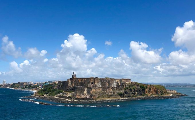 Castillo San Felipe del Morro fortress on the coast of San Juan, Puerto Rico, surrounded by blue ocean and clouds.